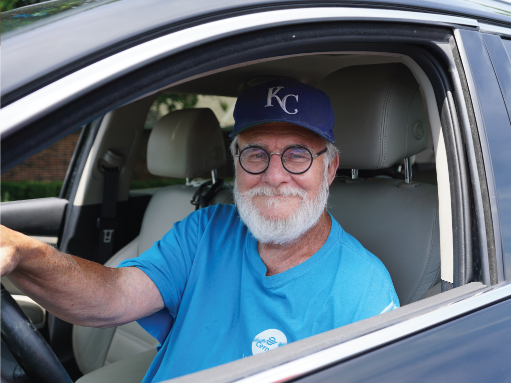 Senior sitting in car at distribution. 